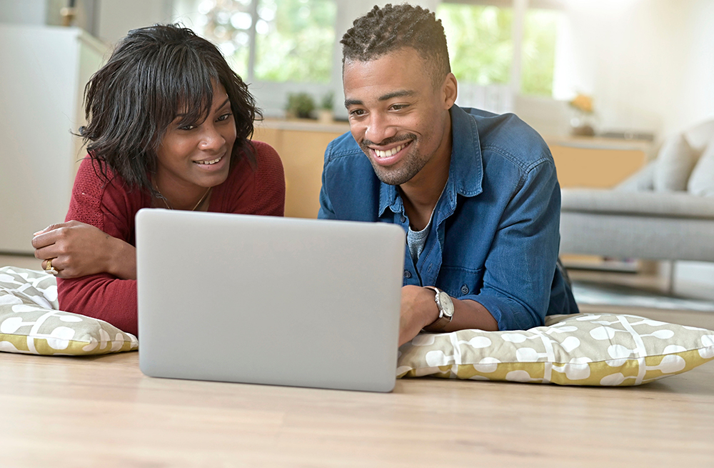 Young couple researching the best continuous glucose monitor on a laptop. 